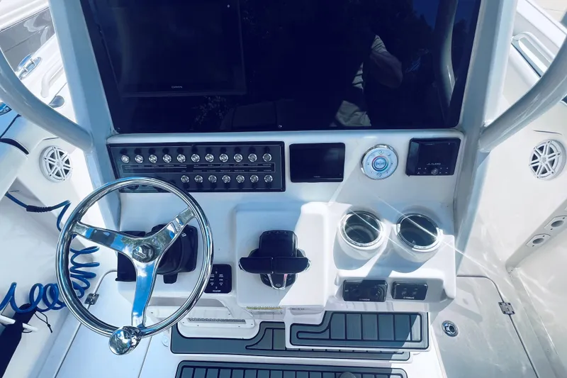 Slide: The Image of 2021 Tidewater 256 CC Adventure boat dashboard with steering wheel and controls. - 29