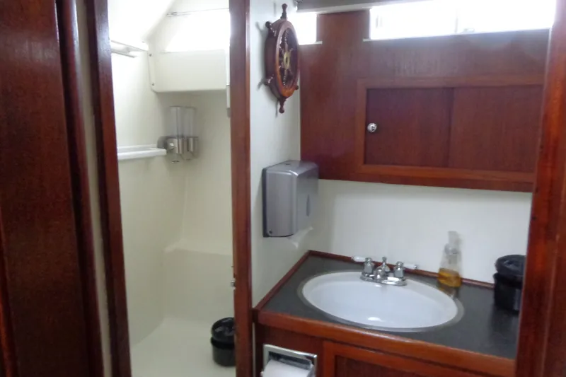 Slide: The Image of 1975 Uniflite Flybridge Sport Sedan bathroom with wooden cabinetry and sink. - 14