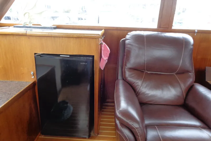 Slide: The Image of 1975 Uniflite Flybridge Sport Sedan interior with leather chair and mini fridge. - 10