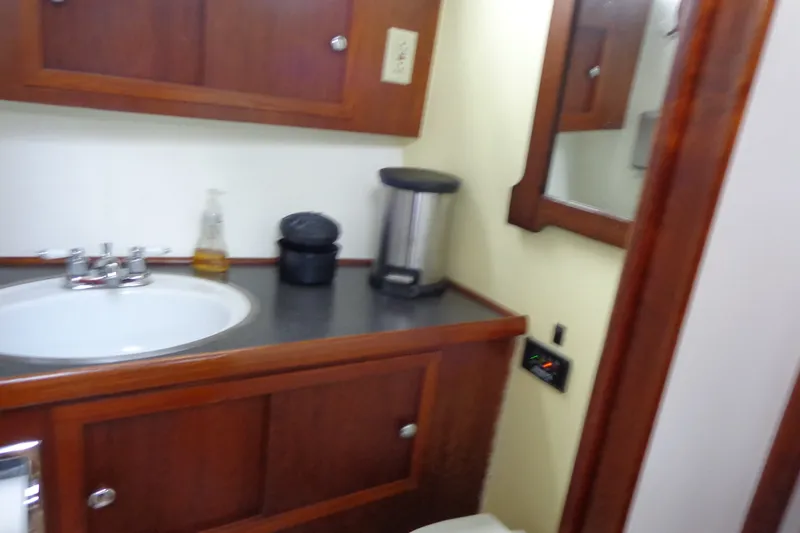 Slide: The Image of 1975 Uniflite Flybridge Sport Sedan bathroom with wooden cabinets and sink. - 15