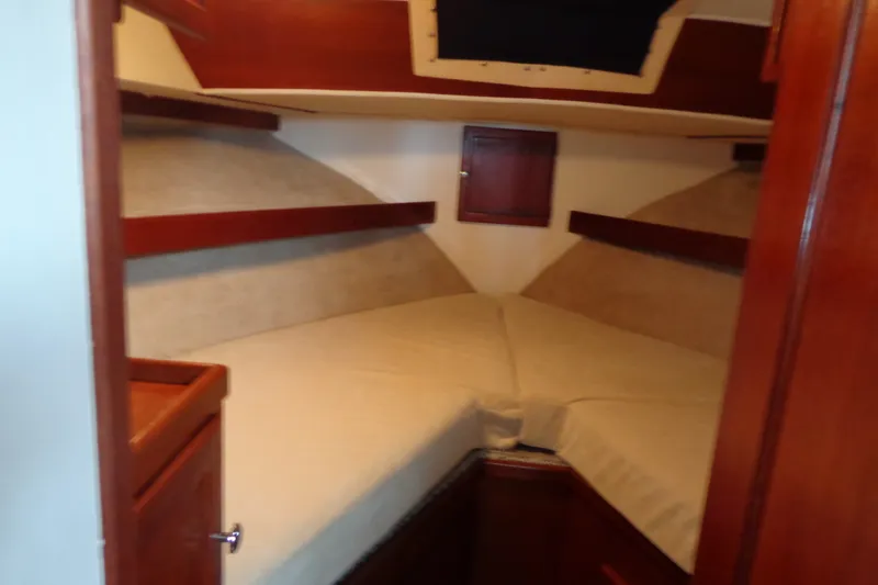 Slide: The Image of 1975 Uniflite Flybridge Sport Sedan cabin interior with cozy V-berth and wooden accents. - 13