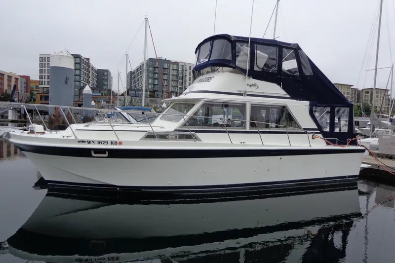 Slide: The Image of 1975 Uniflite Flybridge Sport Sedan docked in a marina, surrounded by modern buildings. - 3