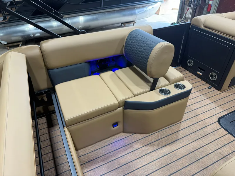 Slide: The Image of Luxurious seating area with beige upholstery and blue lighting on a Bentley Pontoons Elite 223 Swingback Tritoon. - 26