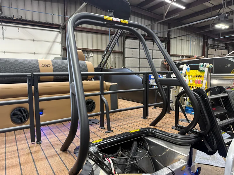 Slide: The Image of The image shows the deck of a Bentley Pontoons Elite 223 Swingback Tritoon with black railings. - 50