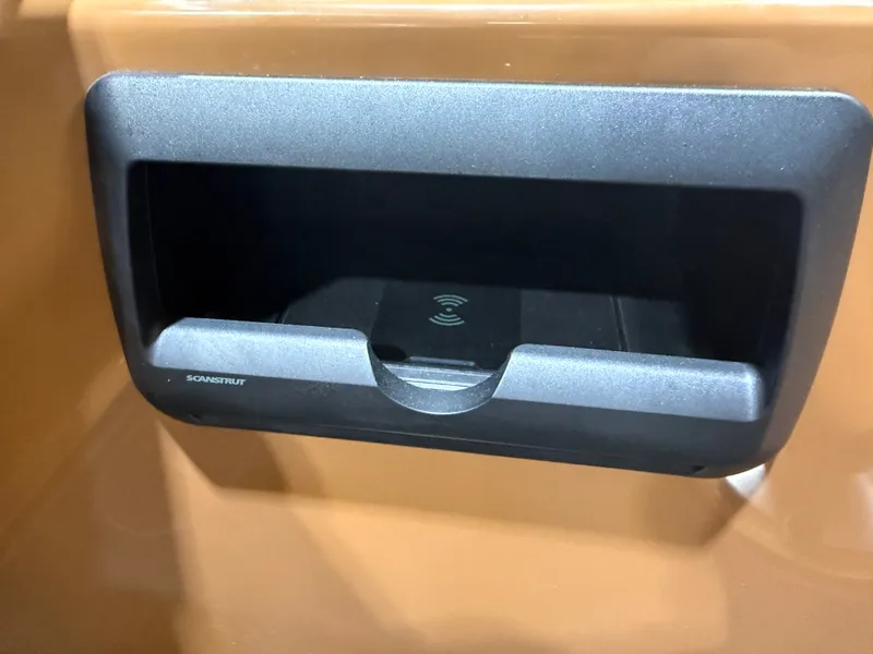 Slide: The Image of A black compartment with wireless charging capability is embedded in a brown surface. - 37