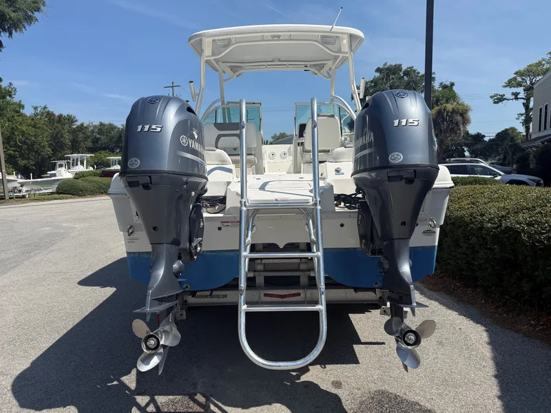 Slide: The Image of A 2023 World Cat 230 DC with twin Yamaha 115 outboard engines, parked in a lot. - 11