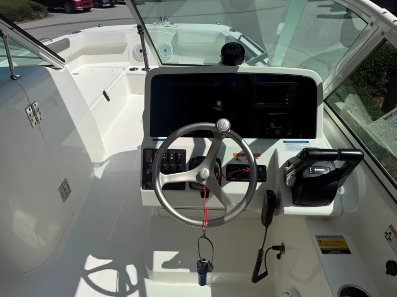 Slide: The Image of The cockpit of the 2023 World Cat 230 DC features a modern steering wheel with instruments and controls. - 6