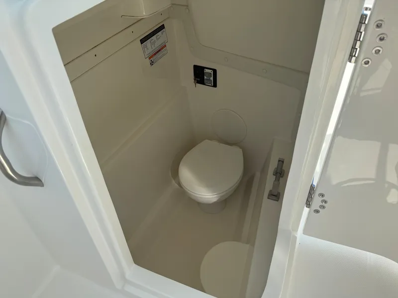 Slide: The Image of The image shows a compact white boat toilet with a closed door and handle. - 3