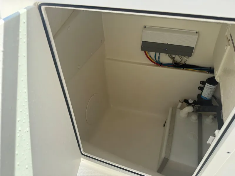Slide: The Image of An empty storage compartment in the boat with visible wiring and connections. - 8