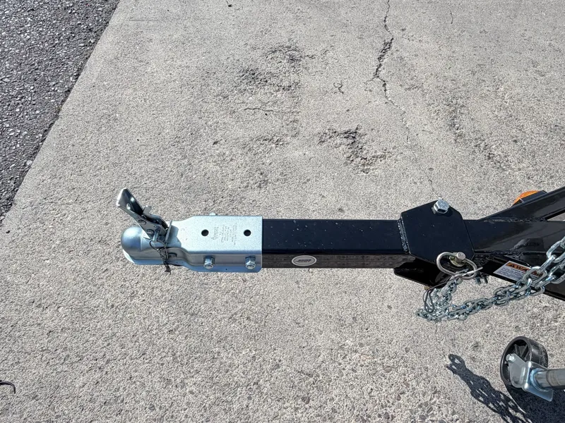 Slide: The Image of Close-up of a trailer hitch on a concrete surface, featuring safety chains and a locking mechanism. - 20