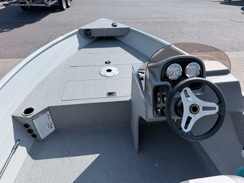 Slide: The Image of The image shows the cockpit of a 2027 Starcraft 16 Patriot DLX SC boat with a steering console. - 17