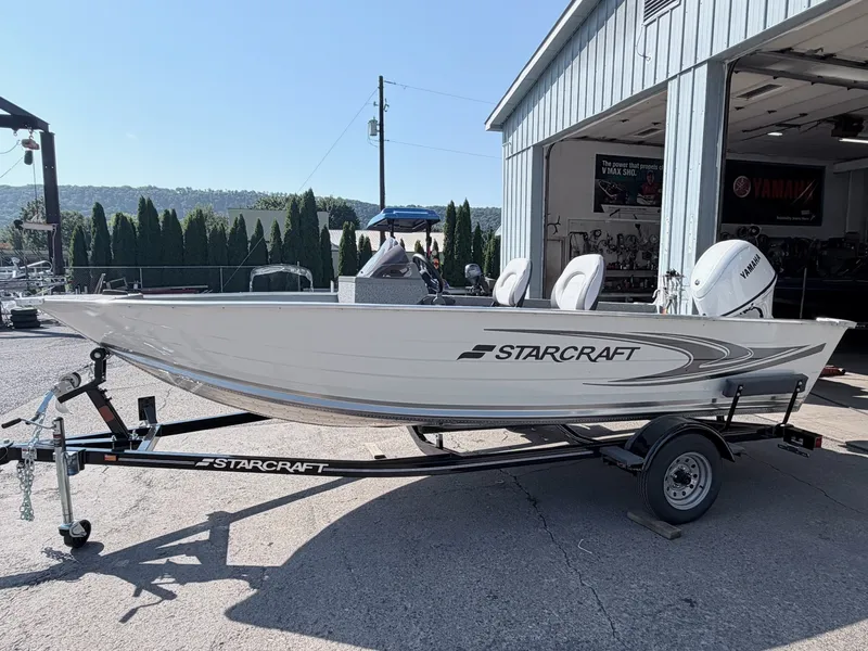 Slide: The Image of A 2027 Starcraft 16 Patriot DLX SC boat on a trailer outside a building. - 15