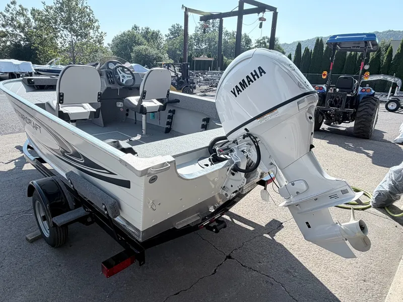 Slide: The Image of A Starcraft 16 Patriot DLX SC boat with a Yamaha outboard motor on a trailer. - 23