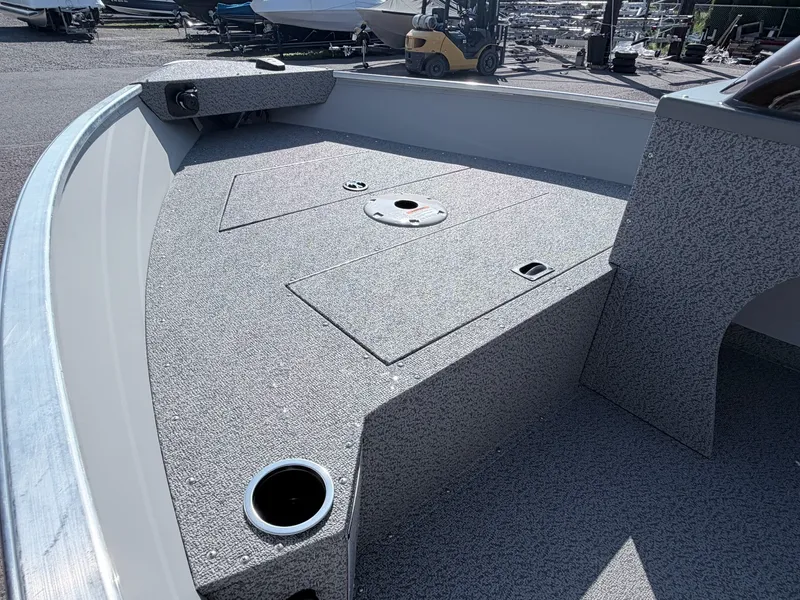 Slide: The Image of The image shows the bow deck of a Starcraft 16 Patriot DLX SC boat. It features a textured surface and cup holders. - 24