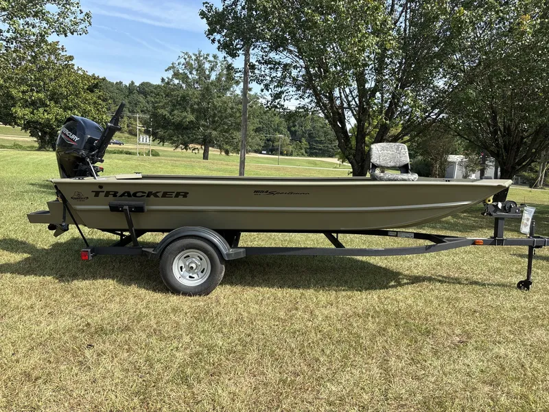 The Image of A 2026 Tracker Grizzly 1654 T Sportsman boat on a trailer, set on a grassy area. - 1