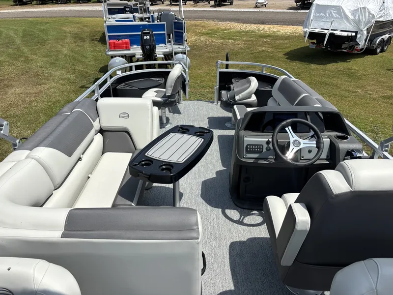 Slide: The Image of The image shows the interior of a 2026 Sun Tracker Fishin' Barge 20 DLX with gray seating and a helm. - 14
