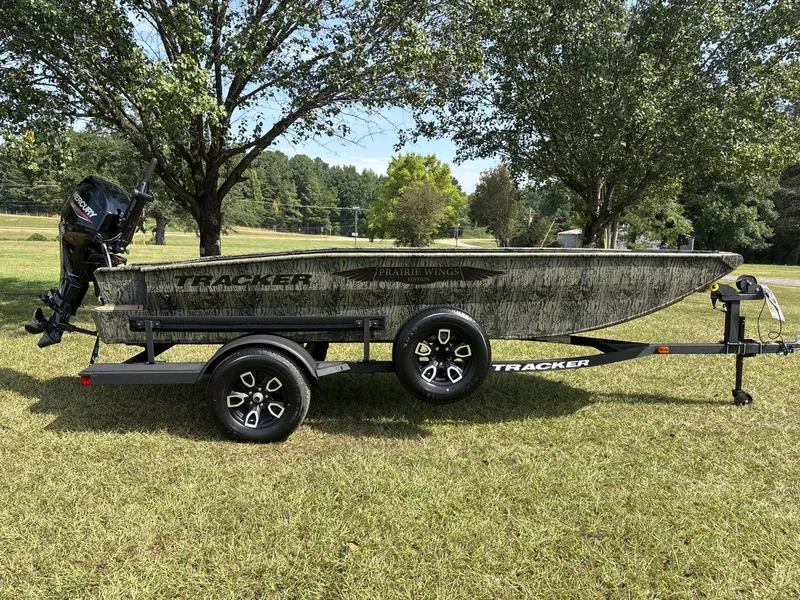 The Image of A 2026 Tracker 1650 T Prairie Wings boat on a trailer, set on a grassy field. - 1
