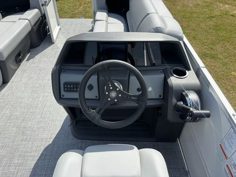 Slide: The Image of The image shows the helm of a 2026 Sun Tracker Party Barge 22 RF DLX with gray seating. - 14