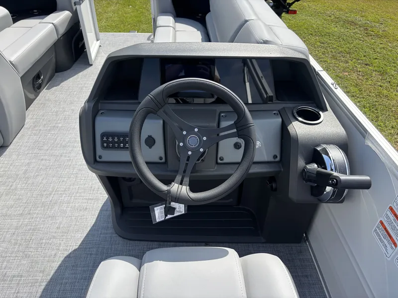 Slide: The Image of The image shows the helm of a 2026 Sun Tracker Party Barge 20 DLX with a modern steering wheel and controls. - 14