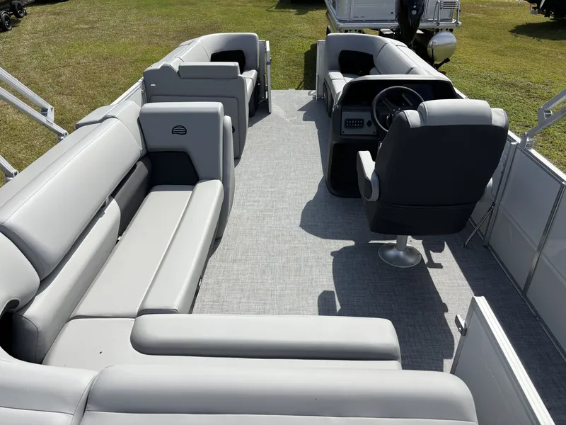 Slide: The Image of The image shows the interior of a Sun Tracker Party Barge 20 DLX pontoon boat with gray upholstery and a helm. - 15