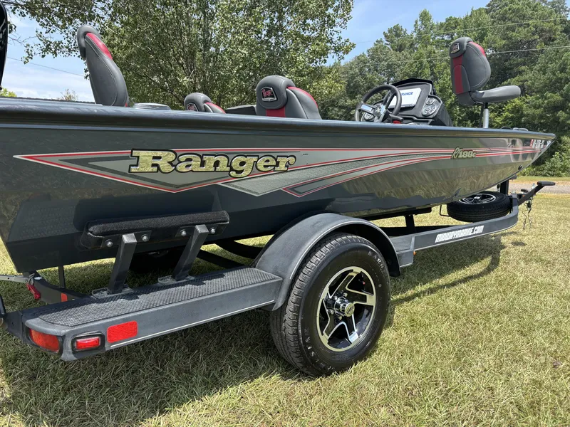 Slide: The Image of A 2025 Ranger RT RT188C boat on a trailer, parked on grass, with trees in the background. - 8