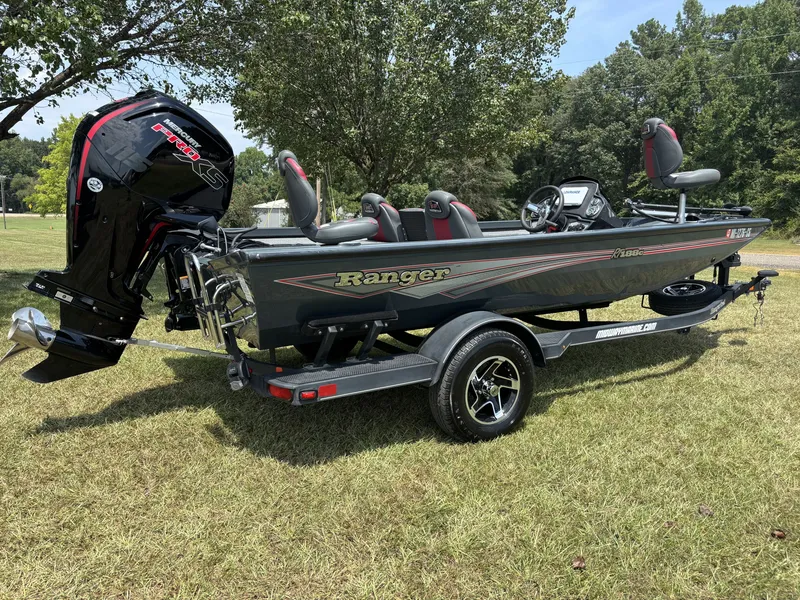 Slide: The Image of A 2025 Ranger RT RT188C boat on a trailer in a grassy area. It features an outboard motor. - 6