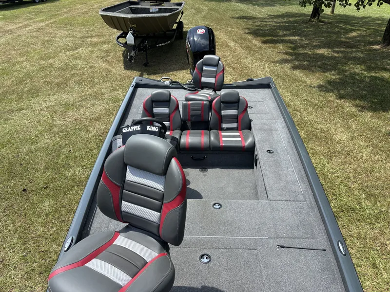 Slide: The Image of The image shows a 2025 Ranger RT RT188C boat with gray and red seats on a grassy area. - 18