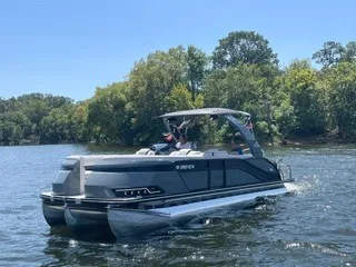 The Image of A 2022 Harris Grand Mariner 250 pontoon boat cruising on a calm lake. - 1