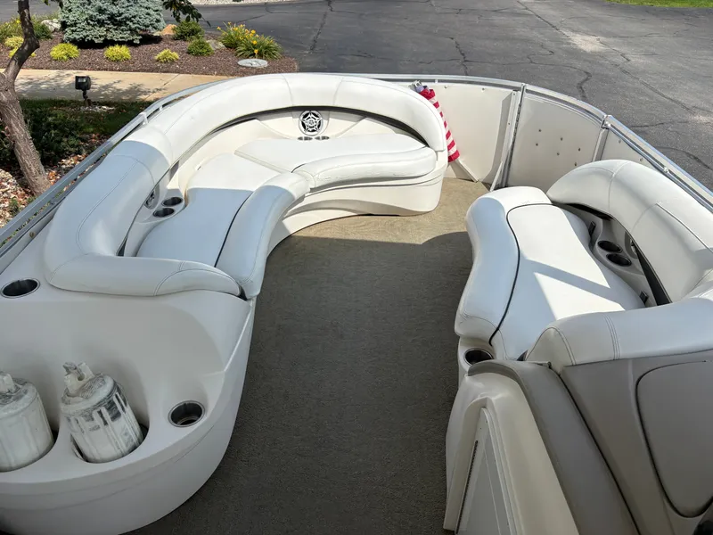 Slide: The Image of The image shows the deck of a 2006 Harris Royal Herritage pontoon boat with white seating. - 14