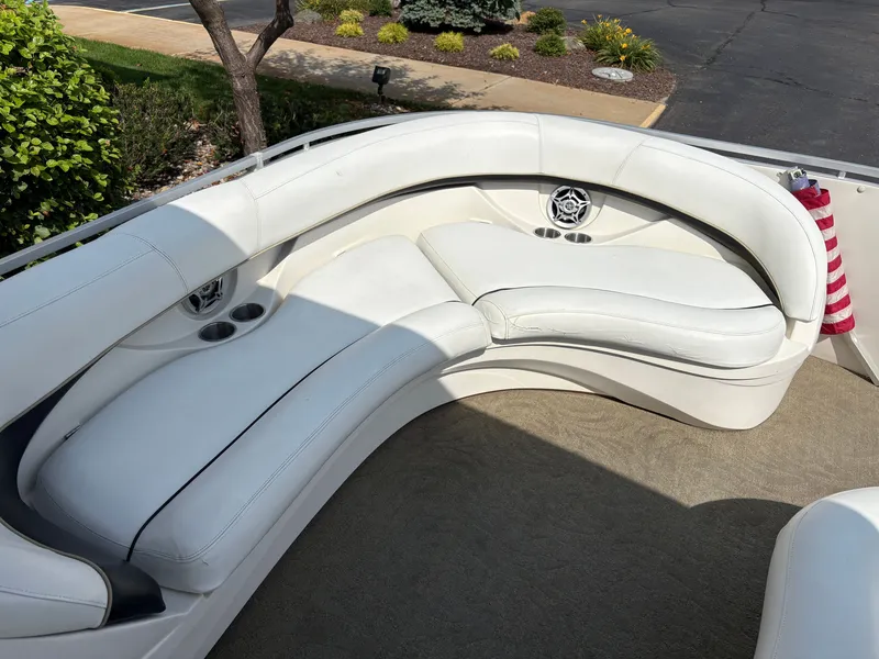 Slide: The Image of The image shows a white, curved seating area on a boat with cup holders. - 16