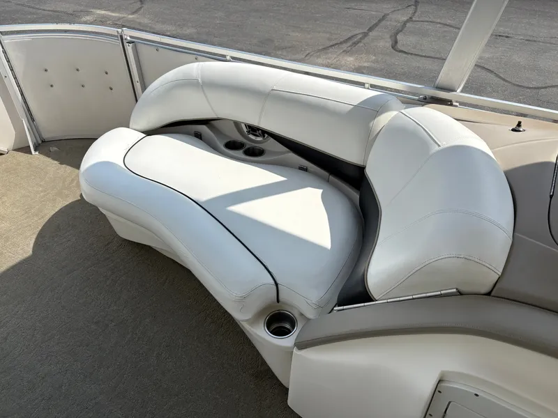 Slide: The Image of The image shows a white, cushioned seating area on a boat with cup holders. - 15