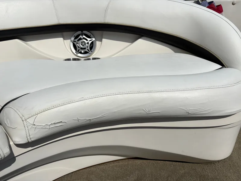 Slide: The Image of White, slightly worn boat seating with speaker and cup holders. - 17