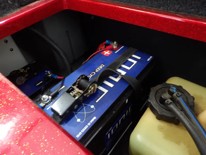 Slide: The Image of A battery compartment with a blue battery and a yellow container in a Nitro Z-7 boat. - 26
