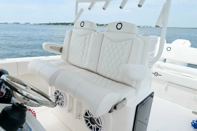 Slide: The Image of 2025 Fountain 34 Tournament Edition boat with luxurious white seating and steering wheel on open water. - 16