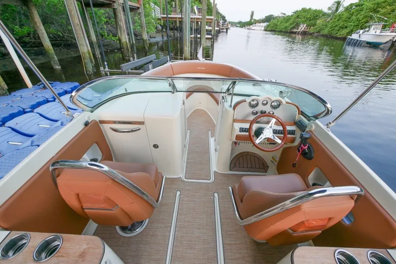 Slide: The Image of 2018 Chris-Craft Launch 27 boat interior with leather seats and wooden steering wheel. - 17