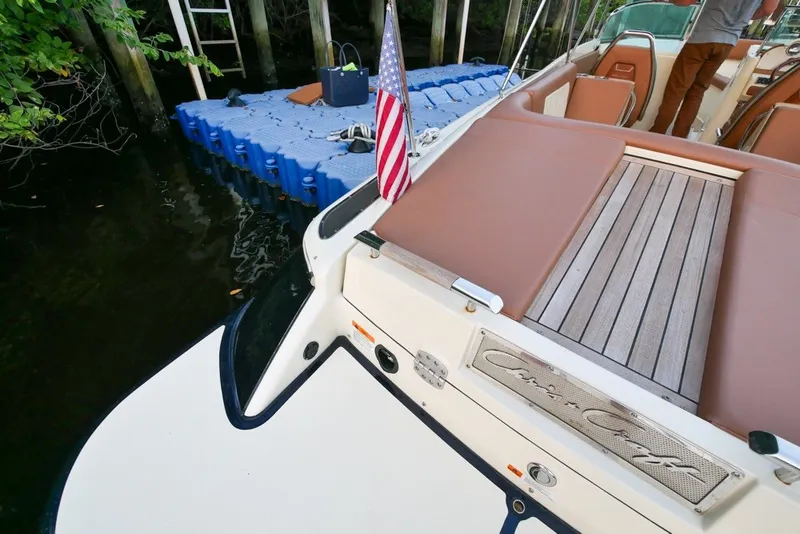 Slide: The Image of 2018 Chris-Craft Launch 27 boat with American flag, docked near floating platform. - 6