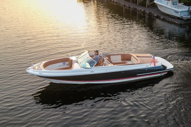Slide: The Image of 2018 Chris-Craft Launch 27 boat cruising on calm water at sunset. - 3
