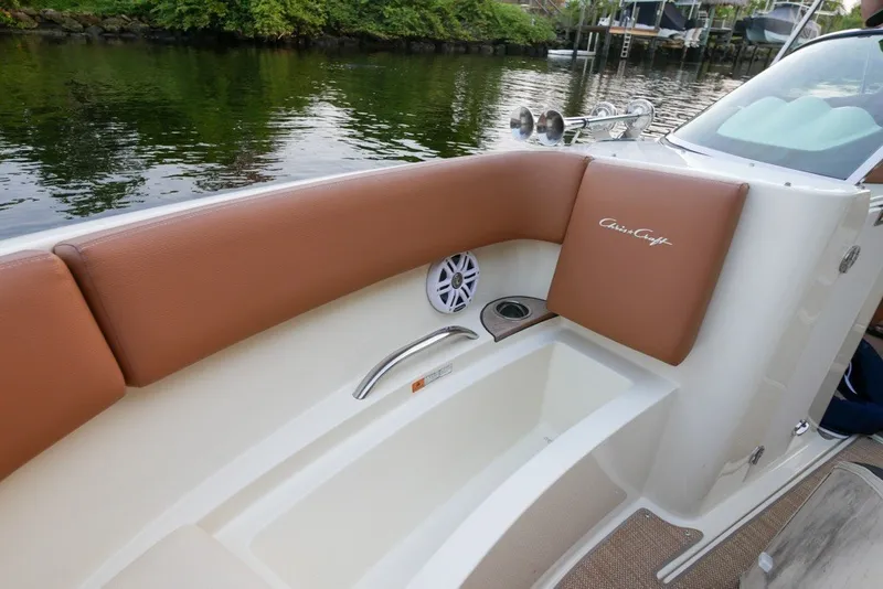 Slide: The Image of 2018 Chris-Craft Launch 27 boat interior with brown seating and speaker detail. - 29