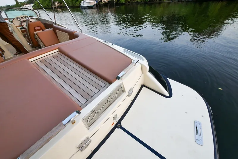 Slide: The Image of 2018 Chris-Craft Launch 27 boat with elegant deck and seating, docked by calm waters. - 7