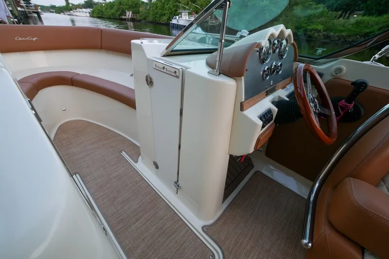 Slide: The Image of 2018 Chris-Craft Launch 27 boat interior with brown leather seating and polished dashboard. - 24
