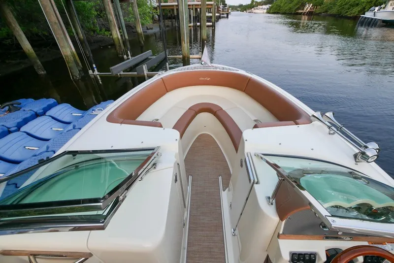 Slide: The Image of 2018 Chris-Craft Launch 27 boat with elegant seating, docked by a serene waterway. - 23