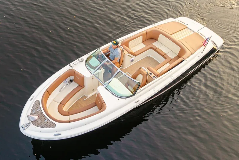Slide: The Image of 2018 Chris-Craft Launch 27 boat cruising on calm water, featuring elegant tan seating. - 1