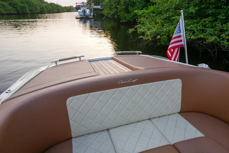 Slide: The Image of 2018 Chris-Craft Launch 27 boat with elegant seating, cruising on a serene waterway. - 9