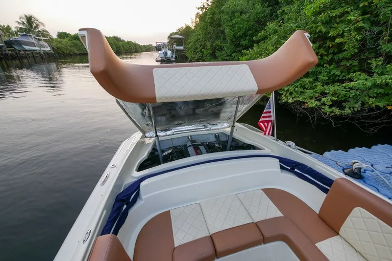 Slide: The Image of 2018 Chris-Craft Launch 27 boat with open engine compartment, docked by lush greenery. - 10