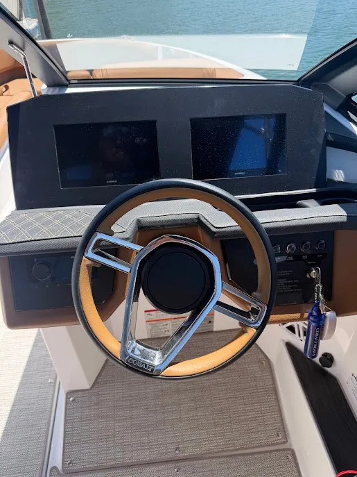 Slide: The Image of The image shows the helm of a Cobalt R26 boat with two screens and a sleek steering wheel. - 14