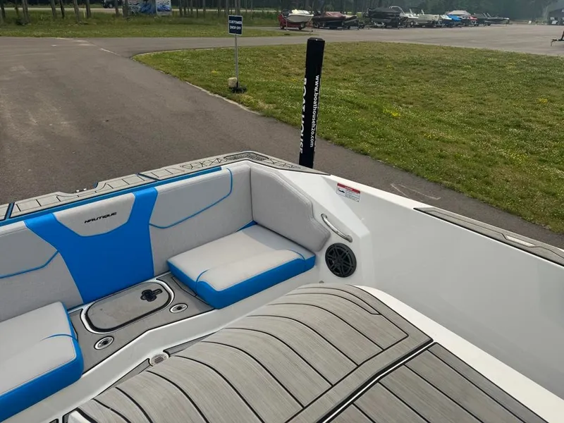Slide: The Image of The image shows the open bow design of a 2025 Ski Nautique 200 with gray and blue upholstery. - 24