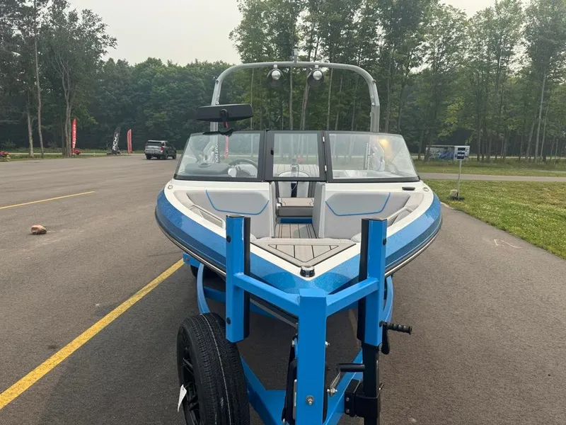 Slide: The Image of A blue and white 2025 Ski Nautique 200 Open Bow on a trailer in a parking area. - 7