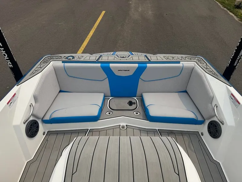 Slide: The Image of The image shows the open bow of a 2025 Ski Nautique 200 with gray and blue upholstery. - 23