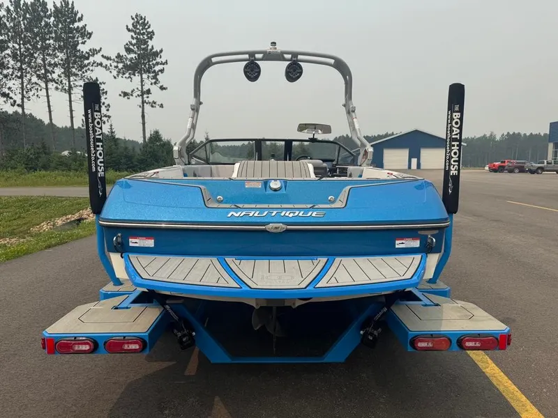 Slide: The Image of A blue 2025 Nautique Ski Nautique 200 Open Bow boat is parked on a lot. It features a sturdy build and modern equipment. - 8