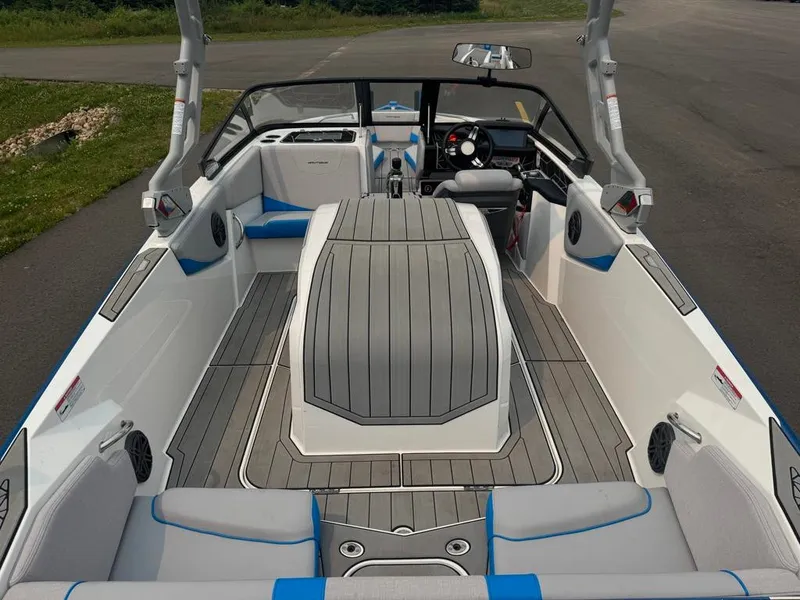 Slide: The Image of The image shows the interior of a 2025 Nautique Ski Nautique 200 Open Bow boat with gray and blue accents. - 13